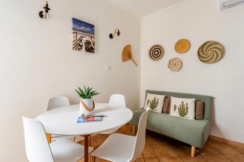 a dining room with a white table and chairs at Vicolo 35 Apartments in Trapani