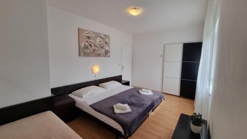 a bedroom with a bed and a table in it at Apartments Josip 2830 in Rab