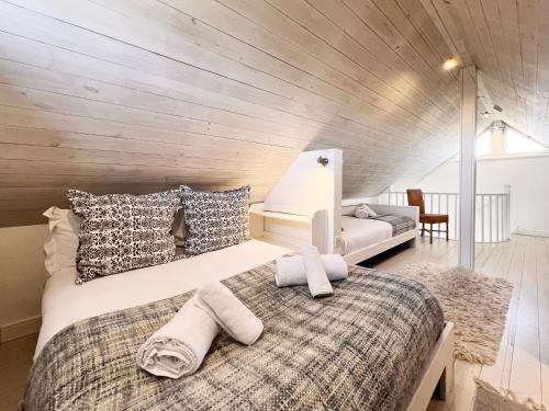 a bedroom with a bed with towels on it at Spinney's Boathouse by The Suffolk Cottage Collection in Thorpeness