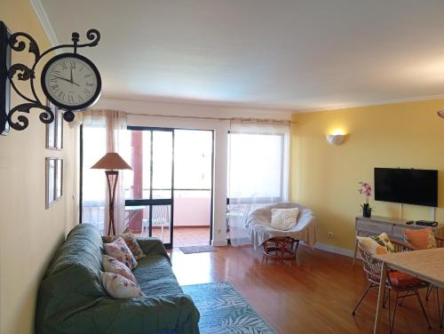 a living room with a couch and a clock on the wall at Apartamento Silvestre Freitas in Funchal