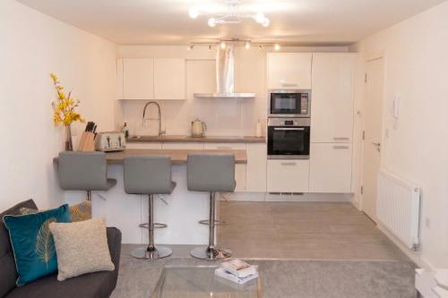 a living room with a couch and a kitchen at Panorama House, Modern 3-Bedroom Apartment 3, Oxford in Oxford