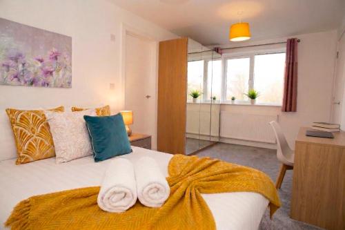 a bedroom with a bed with towels on it at Panorama House, Modern 3-Bedroom Apartment 3, Oxford in Oxford