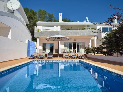 a swimming pool in front of a villa at Burgau Sea View, Beach & Pool Villa in Budens