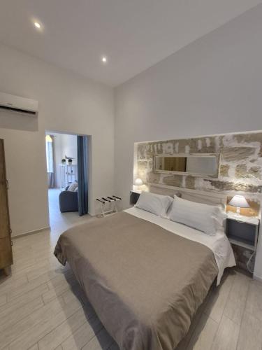 un dormitorio con una cama grande con una pared de piedra en Appartamenti Silva Trapani, en Trapani