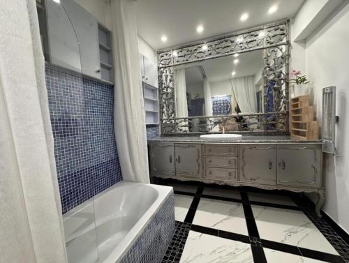 a bathroom with a tub and a large mirror at Villa Del Mar with Heated Pool & Spa in Mazotos