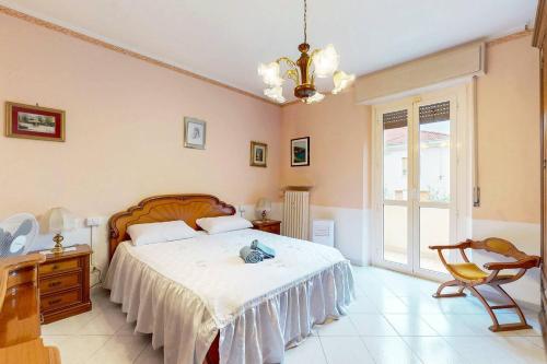 a bedroom with a bed and a chair and a window at [Soleado] Il primo caffè con il sole da 3 lati in Acqui Terme