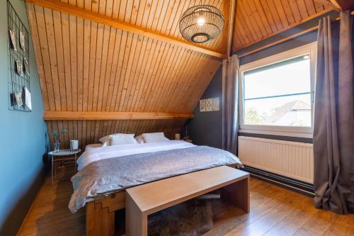 a bedroom with a bed and a large window at Veerse Meer Lodge in Wolphaartsdijk