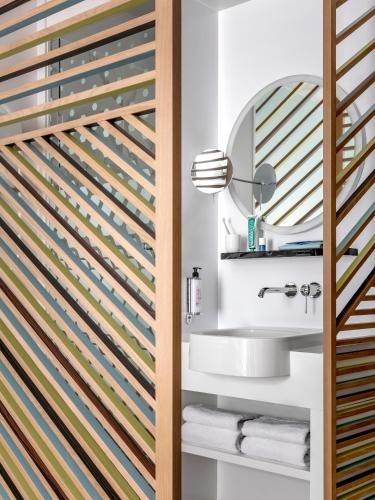 a bathroom with a sink and a mirror at OKKO Hotels Lille Centre in Lille