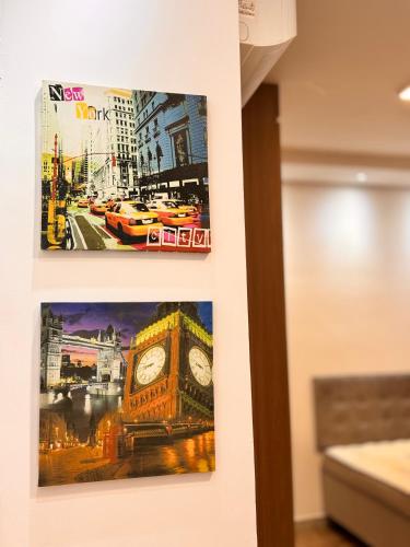 two pictures of big ben are hanging on a wall at STUDIO Flat B in Betim