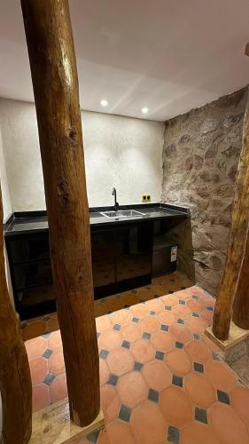 a kitchen with a sink and a stone wall at KASBAH LA DAME BIJA in Ouirgane