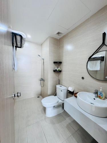 a bathroom with a white toilet and a sink at AC Nera Garden Apartment in Thôn Văn Dương