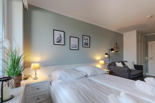 a bedroom with a white bed and a chair at Top gelegene Ferienwohnung mit Balkon direkt im Zentrum von SPO in Böhl