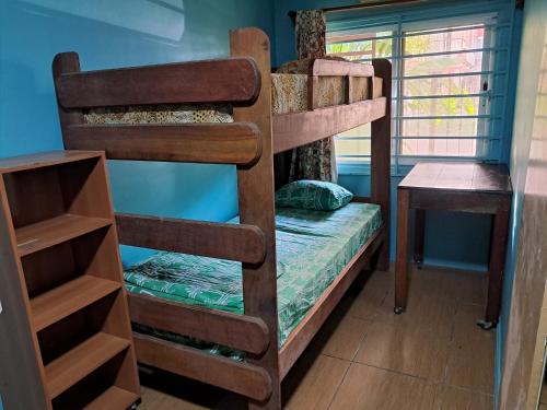 a bedroom with two bunk beds and a table at Hostel Archimedes in Paramaribo