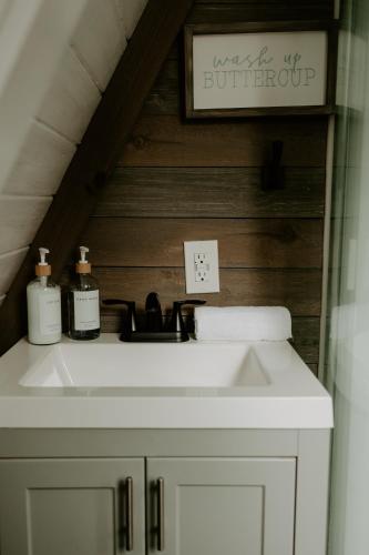 a bathroom with a sink and a sign on the wall at Emerald Escape in Grayling