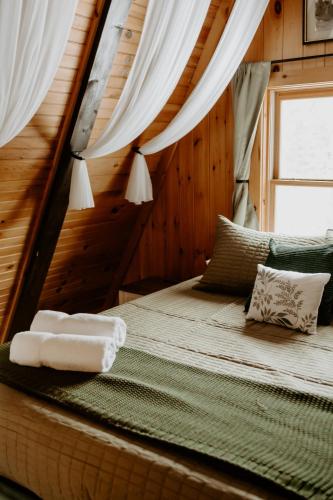 a bedroom with a bed with two towels on it at Emerald Escape in Grayling