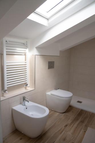 a bathroom with a sink and a toilet and a skylight at Villa Serena - Armonia Apartment in Tirrenia