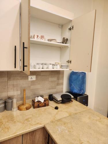 a kitchen with white cabinets and a counter top at Ranachalet-1 in Ash Shāghūr