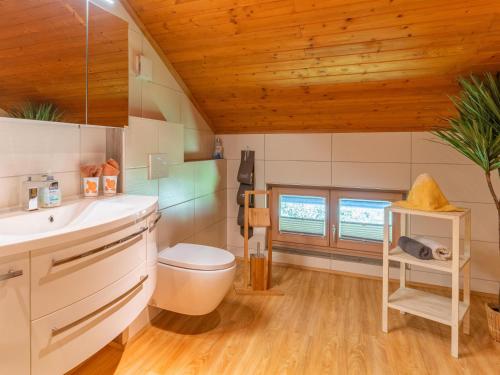a bathroom with a toilet and a wooden ceiling at Wieshof in Kaltenbach