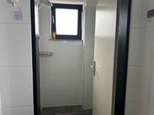 a bathroom with a toilet and a window and a door at Boberger Hostel in Hamburg