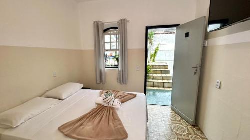 a bedroom with a bed with a doll on it at Pousada Angellus in Paraty