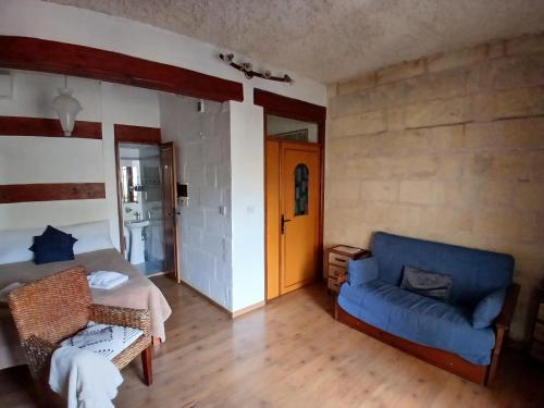 a room with a bed and a blue couch at Gozo Duplex Studio overlooking historic Piazza in Victoria