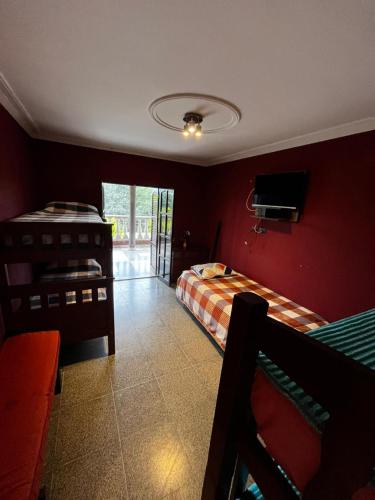 a bedroom with two beds and a tv in it at casa cusi in Tafí Viejo