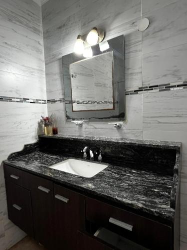 a bathroom with a sink and a mirror at casa cusi in Tafí Viejo