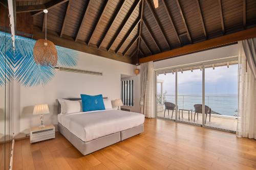 a bedroom with a bed and a view of the ocean at Bluesiam Villa - SHA Certified in Surin Beach
