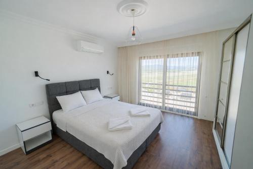 a bedroom with a large bed and a large window at Villa Everest in Dalaman