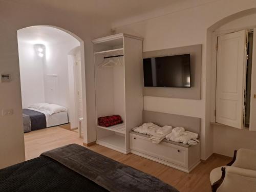 a bedroom with a room with a bed and a tv at Antica Dimora Petito Luxury in Matera
