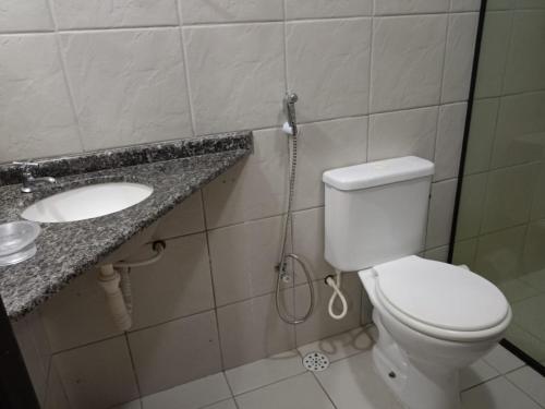a bathroom with a toilet and a sink at Casa disponível para esse final de semana, Barramar House in Barra de São Miguel