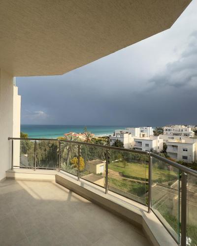 a balcony with a view of the ocean at Apartment with sea view and pool access in Chott Meriem