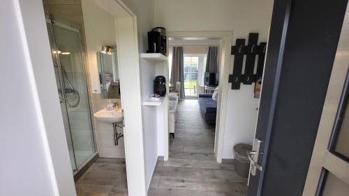 a hallway with a bathroom with a sink and a mirror at Hotel Schleimünde in Kappeln