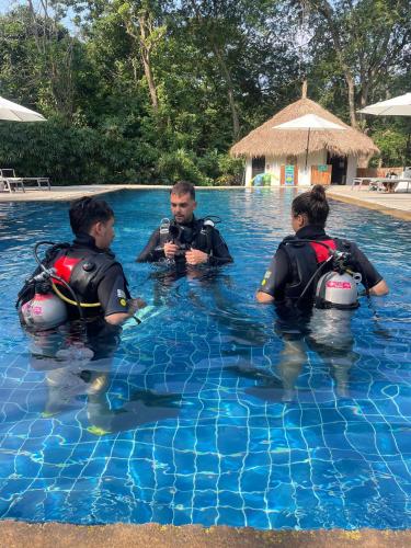 three people in the water in a swimming pool at Chalok Reef Divers Hostel in Ko Tao