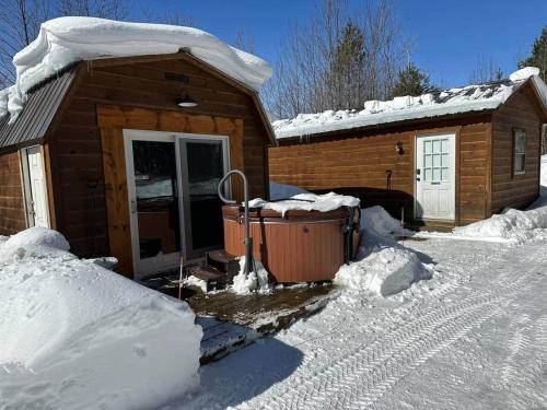 a log cabin with snow on the ground next to it at The Buck Shack in Elmira