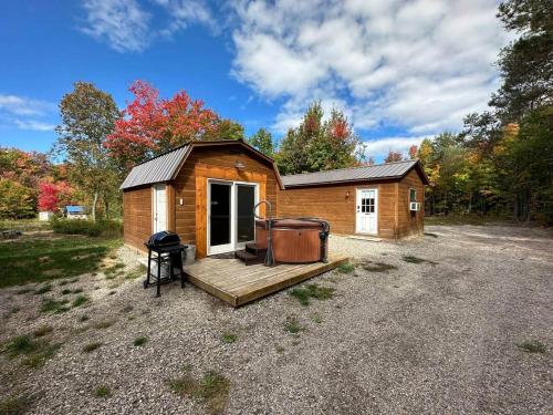 a small cabin with a deck and a grill at The Buck Shack in Elmira