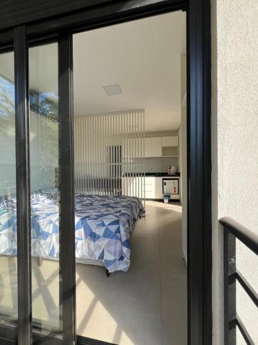 a bedroom with a bed and a view of a kitchen at Suíte completa com cozinha e hidromassagem in Torres