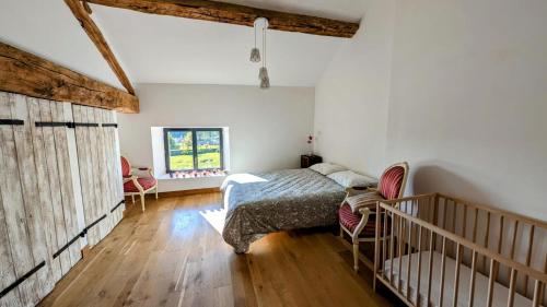 a bedroom with a bed and a crib in it at Belle vue in Dournazac