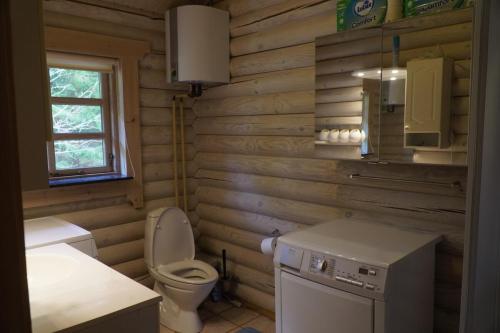 a wooden bathroom with a toilet and a sink at The Log Cabin in Hadsund