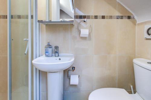 a bathroom with a sink and a toilet and a shower at Hampstead Residence Hotel in London