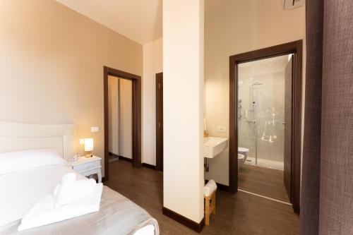 a bedroom with a bed and a bathroom with a sink at Hotel Gardenia Sirmione in Sirmione