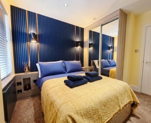 a bedroom with a bed with blue pillows on it at Bournemouth Luxury Apartment in Bournemouth