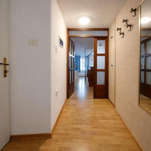 a hallway with white walls and a wooden floor at Ellipse apartment in Piran