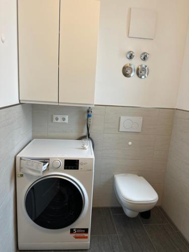 a small bathroom with a washing machine and a toilet at Apartment Seeglück am Schliersee - modern, zentral, perfekt für Familien in Schliersee