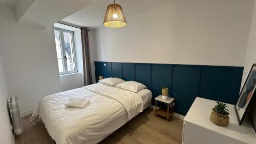 a bedroom with a large bed with a blue headboard at la capeline in Chablis