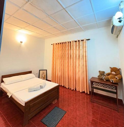 a bedroom with a bed and teddy bears on a table at Laa Villa Kandy in Kandy