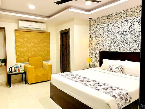 a bedroom with a bed and a yellow chair at Hotel MEGA International Airport Zone in Hyderabad