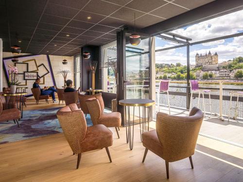 a waiting room with chairs and a large window at Mercure Bords de Loire Saumur in Saumur