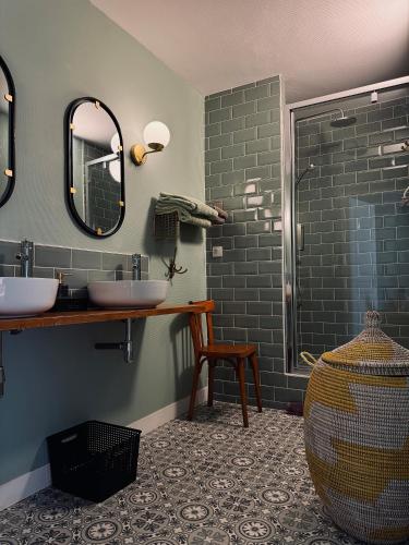 a bathroom with two sinks and a shower at Maison Lasmarenx chambres d'hôtes in Jurançon