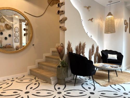 a living room with a mirror and stairs at Montroig 5 hotel boutique in Sitges